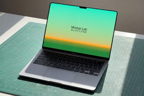 MacBook Pro with green yellow gradient display on craft cutting mat