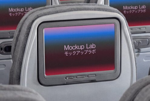Airplane seat-back screen showing colorful gradient mockup in passenger cabin