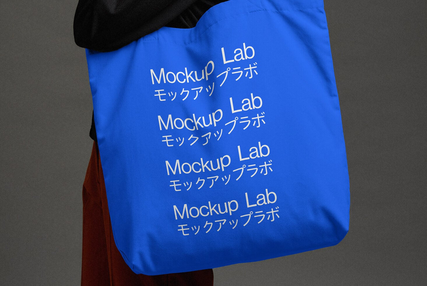 Cobalt blue tote with repeating white text held over shoulder