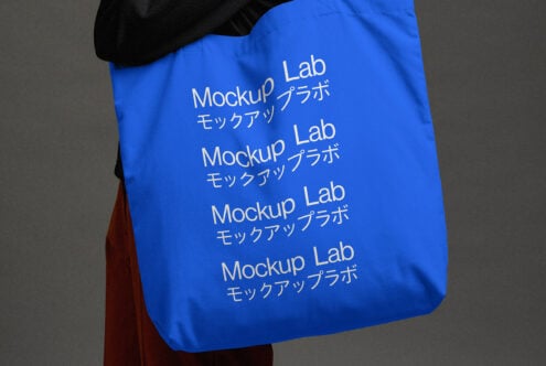 Cobalt blue tote with repeating white text held over shoulder