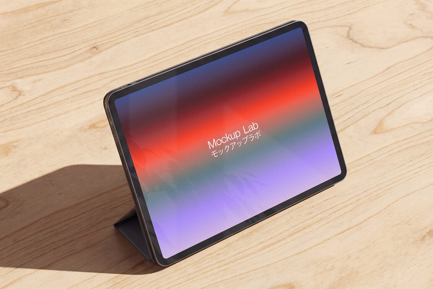 Tablet on light wood showing bright red to purple gradient design on screen