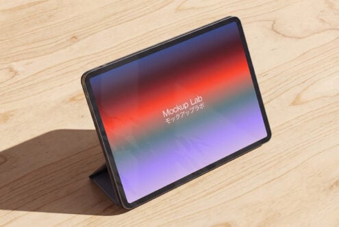 Tablet on light wood showing bright red to purple gradient design on screen