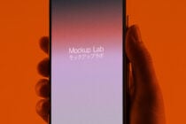 Hand gripping smartphone with soft gradient mockup on orange studio backdrop