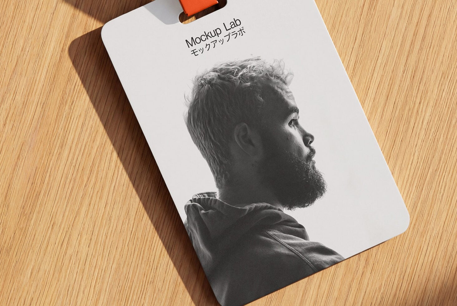 White badge with orange lanyard showing bearded man's side profile photo
