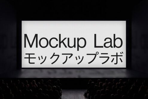 Large theater projection screen with bold black text on white, crowd silhouettes below