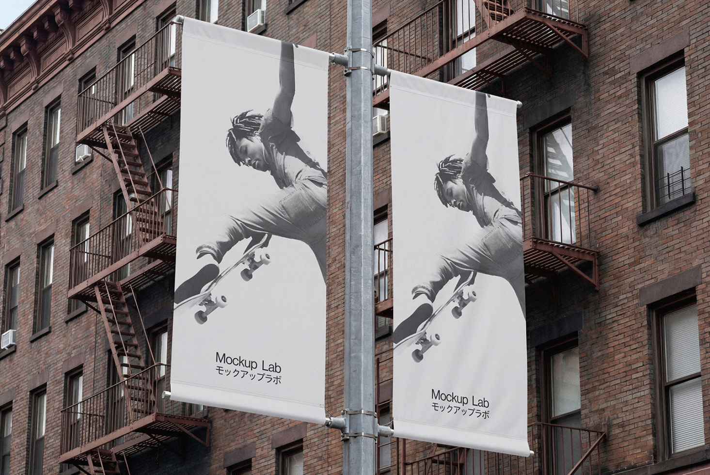 Two white street banners on brick facade with skateboard imagery in black ink