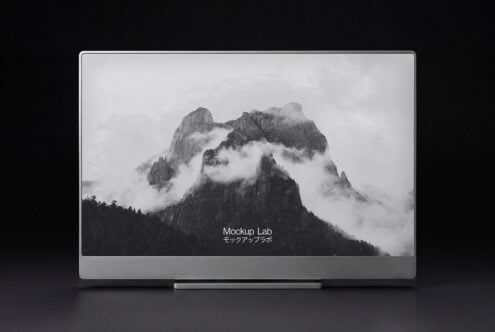 Desktop monitor displaying misty mountain landscape photograph in grayscale