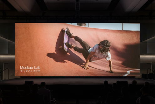 Wide cinema projection screen with person doing parkour flip on orange surface