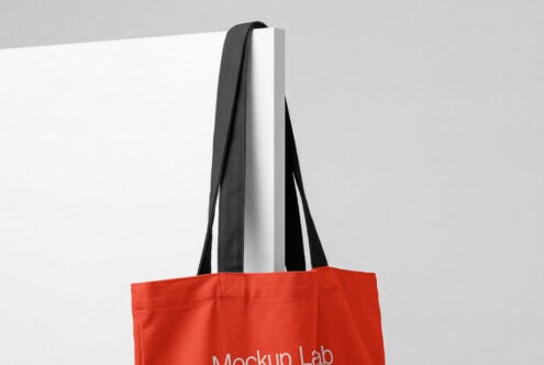 Red tote bag front view with black handles on white studio background