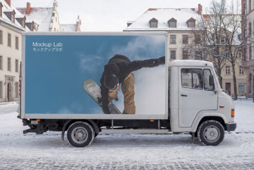 White truck cargo box with snowboarder photo against blue sky in snowy town square