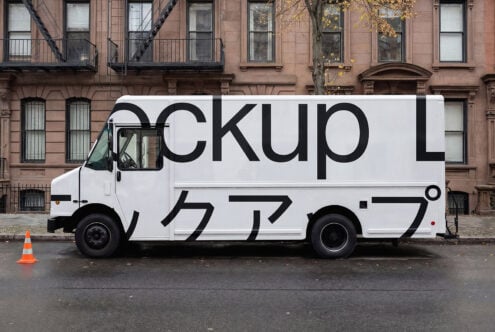 White box truck with large black typography mockup against brownstone
