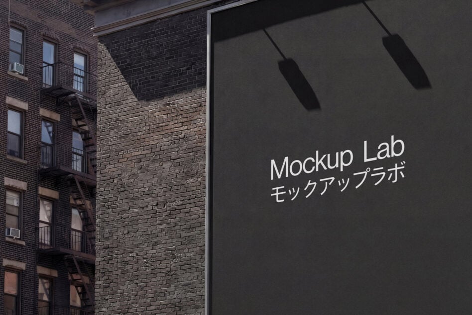 Dark storefront signage on brick wall with shadow details from overhead lighting fixtures