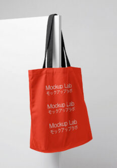 Red tote bag with black handles displaying repeated Mockup Lab branding