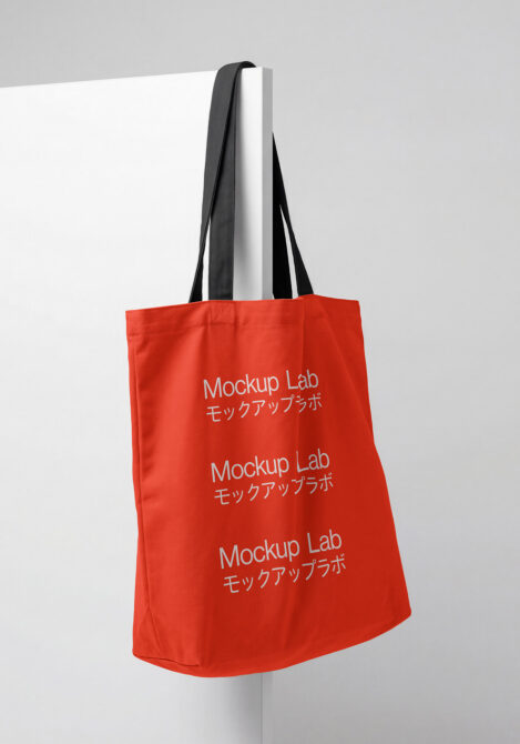 Red tote bag with black handles displaying repeated Mockup Lab branding