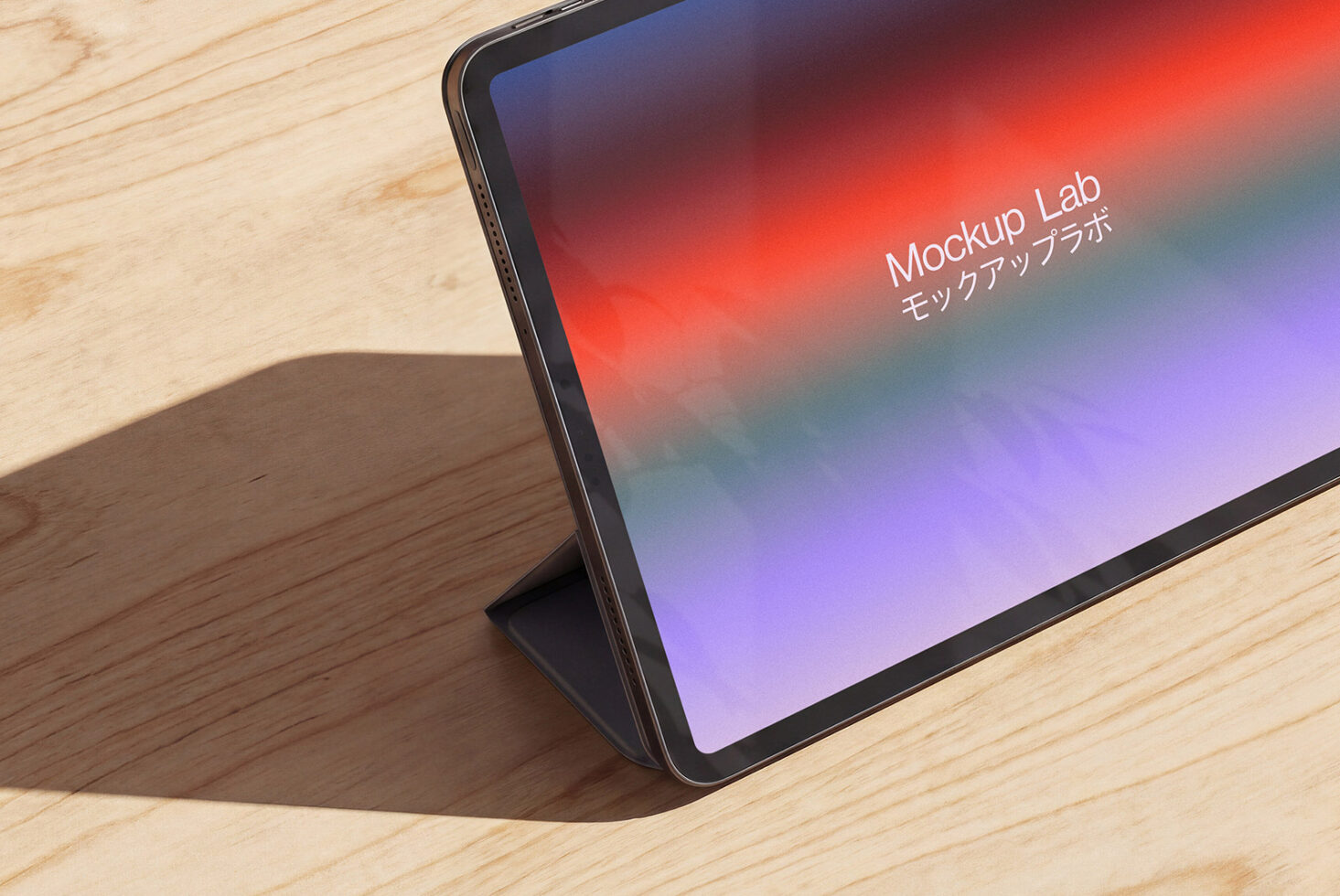 Tablet on wooden desk showing vibrant red to purple gradient with text overlay