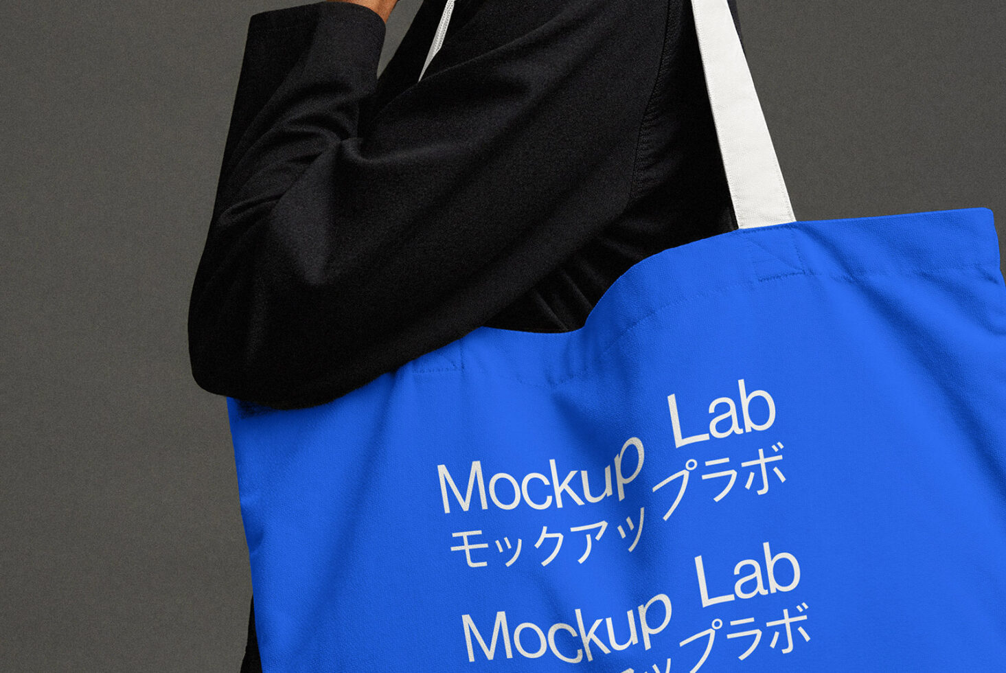 Person carrying bright blue tote bag with repeated text print