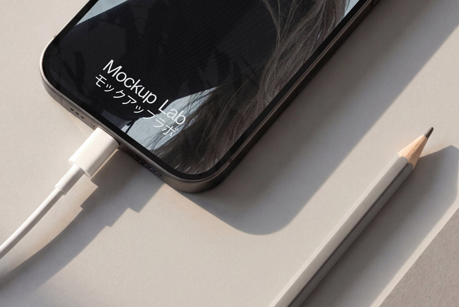Phone flatlay with stylus showing dark screen with reflected hair imagery