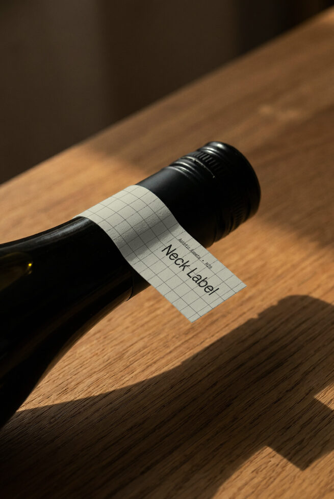 Wine bottle with white grid label mockup on wooden surface with warm lighting