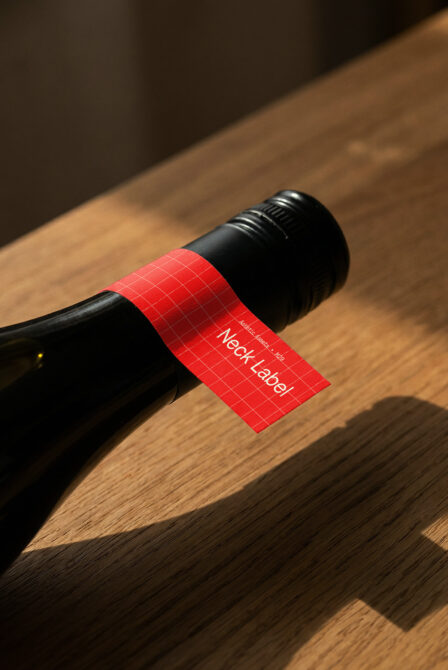 Wine bottle with bright red grid label mockup on wooden surface setup