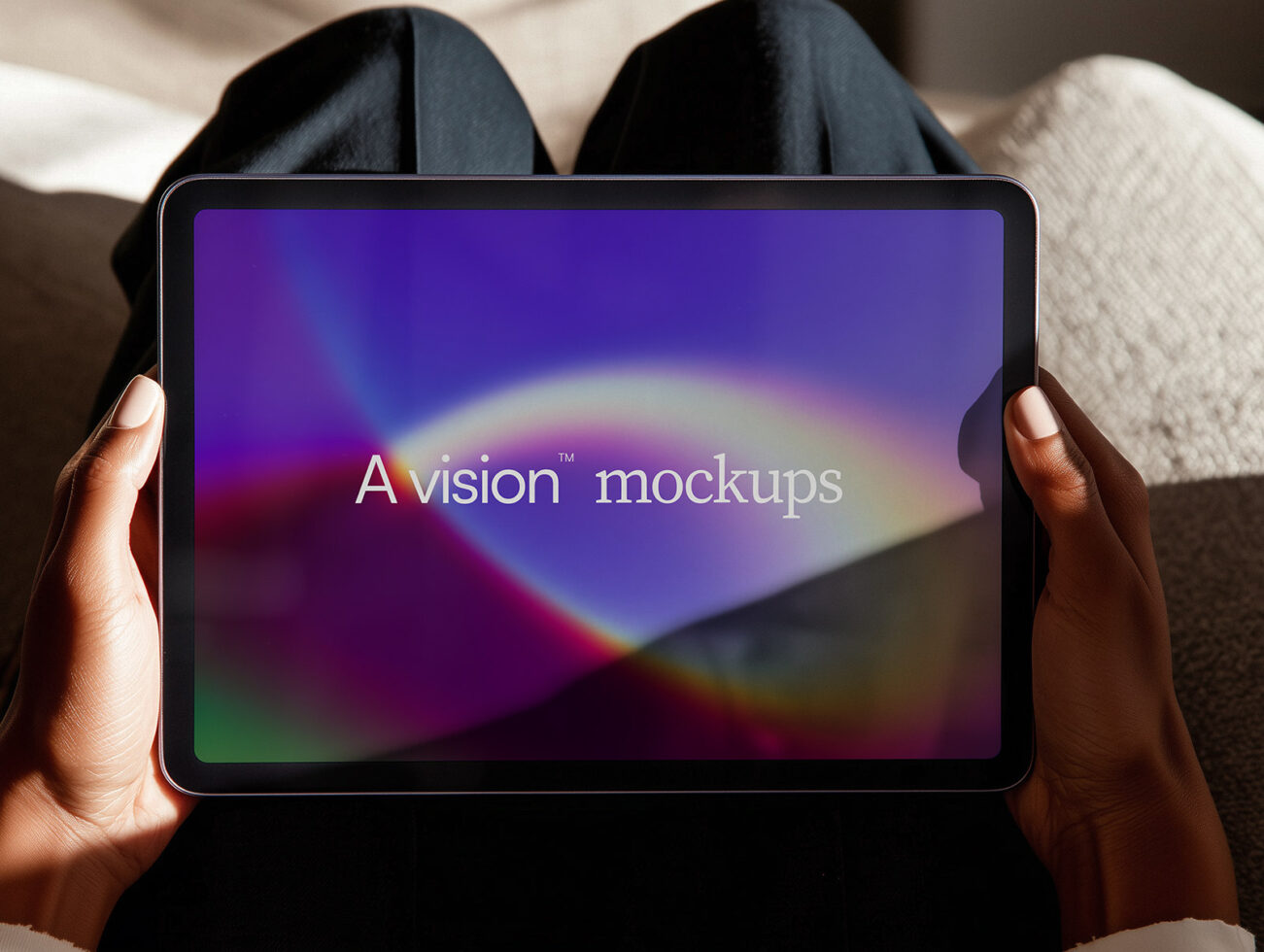 Hands holding tablet device displaying A vision mockups text with colorful gradient wallpaper on screen