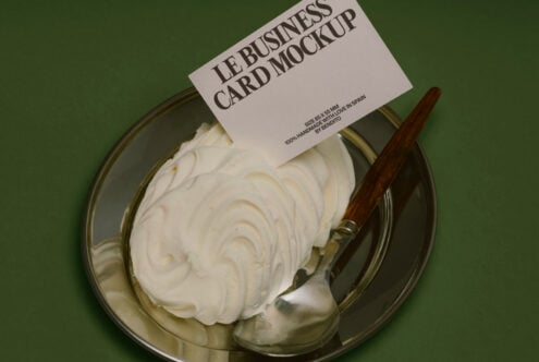 Cream spread on glass plate with wooden knife on green background