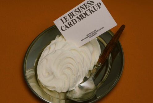 Cream spread on glass plate with wooden knife on brown background