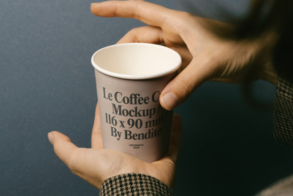 Hands cradling takeaway coffee cup with branded text label showing