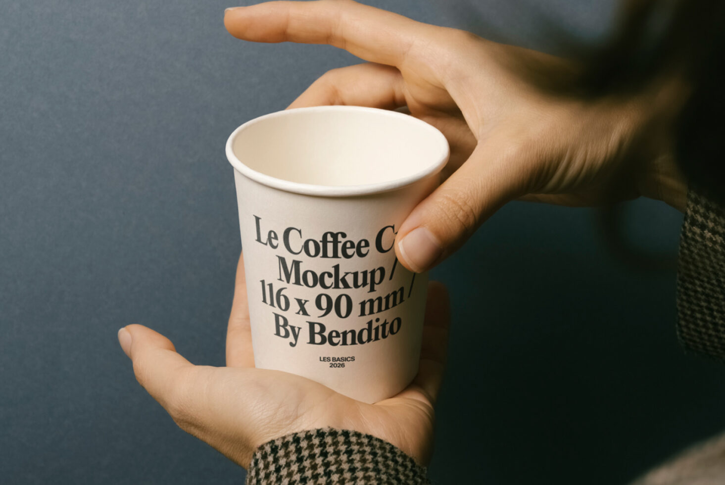 Hands holding plain white paper coffee cup in overhead perspective shot