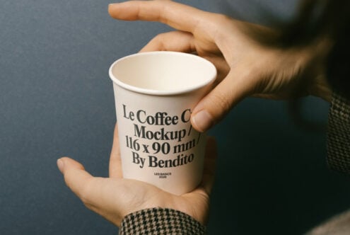 Hands holding plain white paper coffee cup in overhead perspective shot
