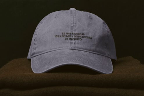 Washed grey cap with embroidered text on front against dark background
