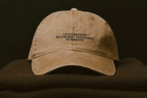 Vintage tan baseball cap with embroidered text displayed on neutral backdrop