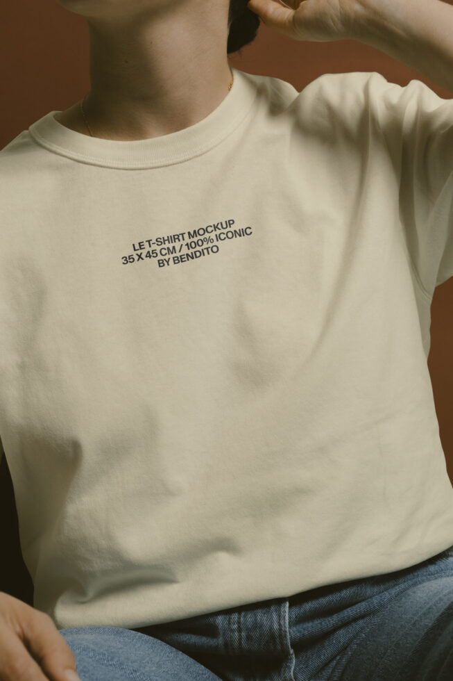 Cream colored t-shirt on person showing Let Shirt Mockup text printed on chest