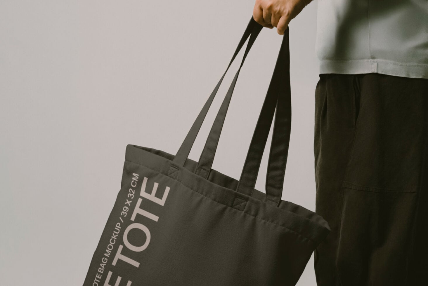 Close up of black canvas tote bag with Let Tote Bag Mockup text visible on front panel