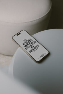 White iPhone propped on cream ceramic bowl in clean product shot