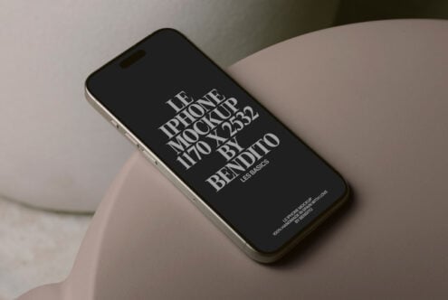 Black iPhone 14 Pro mockup leaning against beige organic ceramic vessel