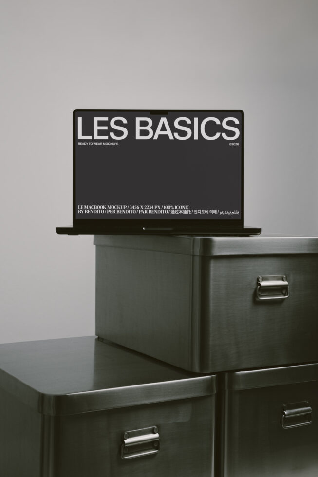 MacBook laptop displaying black screen with Les Basics branding, sits on metal filing cabinet