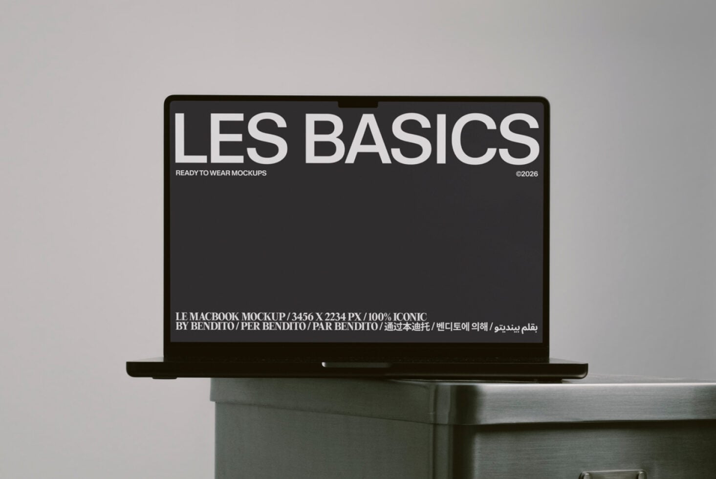 MacBook mockup with dark screen showing Les Basics branding on desk