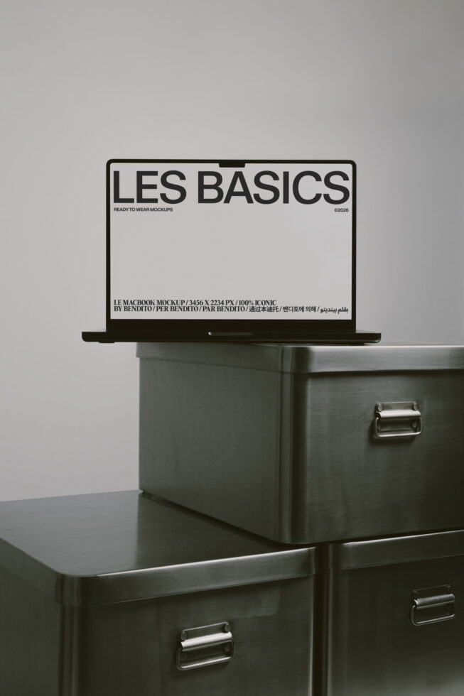 Open laptop showing light screen with Les Basics text, positioned on industrial storage unit