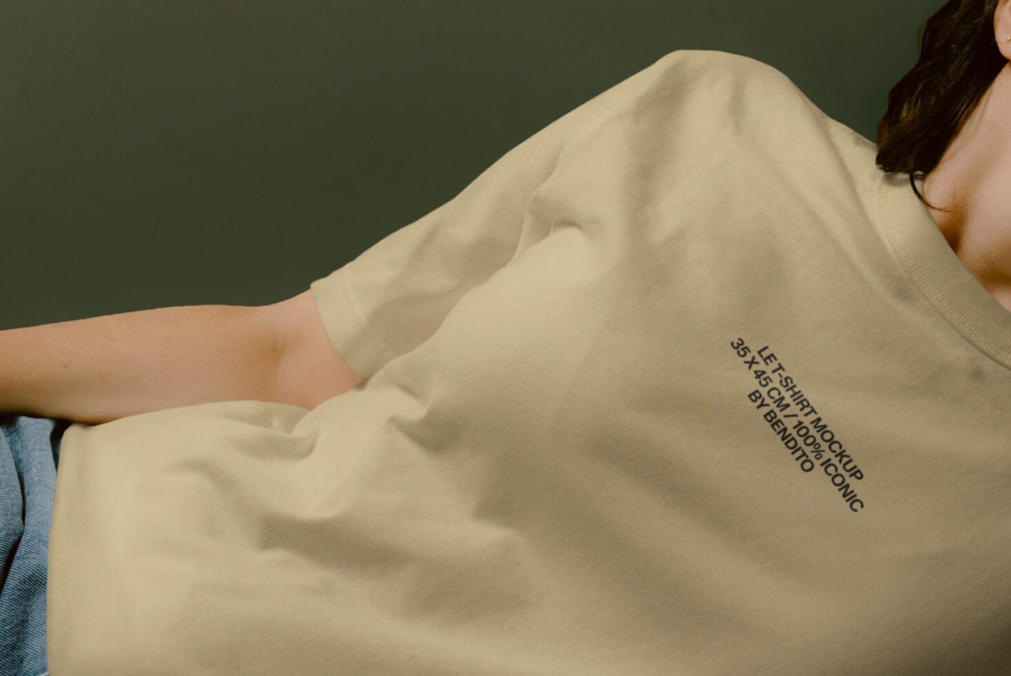 Beige crewneck tee with minimal print on torso, shot against sage green wall