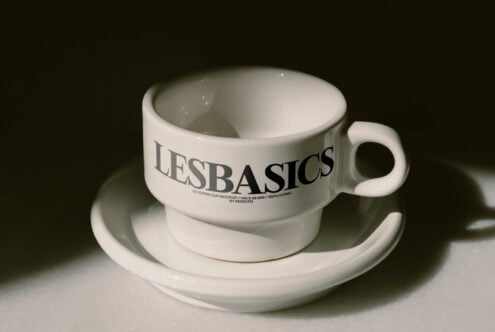 White stoneware mug on matching saucer with LE BASICS branding visible