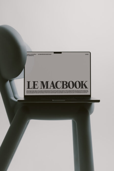 Muted blue-green chair supporting black MacBook with neutral screen mockup