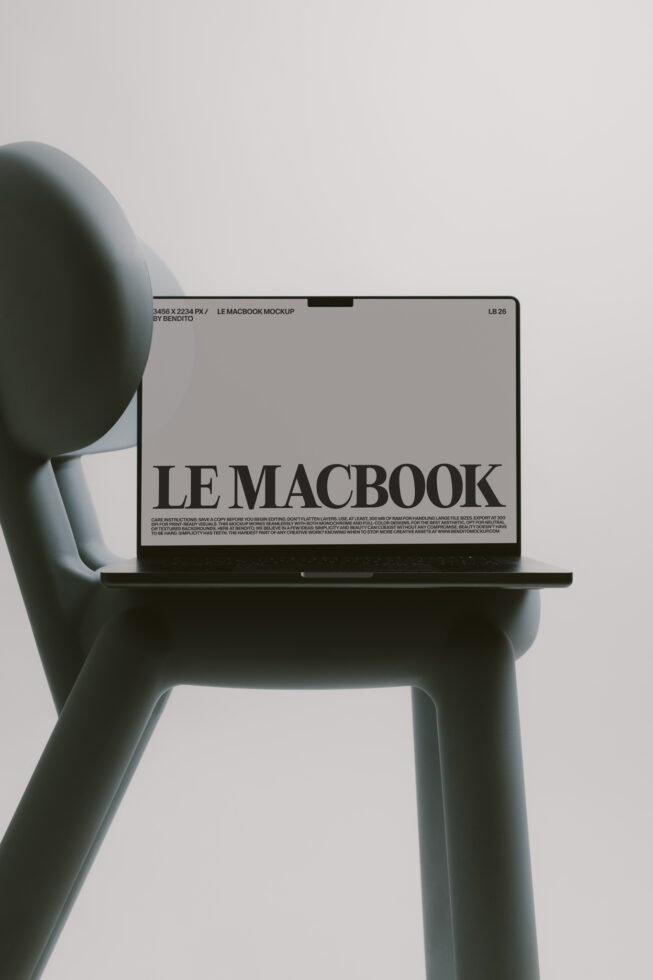 Muted blue-green chair supporting black MacBook with neutral screen mockup