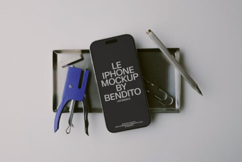 iPhone mockup flat lay with blue leather phone sleeve, pens, scissors in metal tray