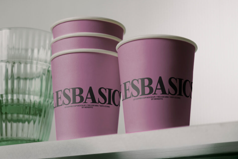 Two pink coffee cups with beige rim labeled LESBASIC on shelf