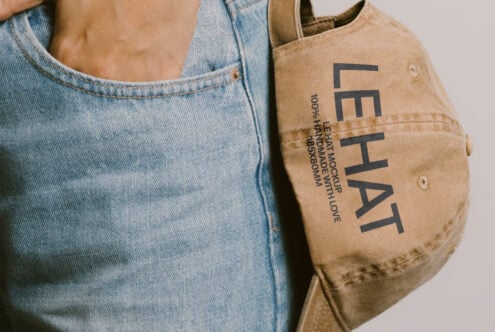 Light denim paired with tan canvas tote displaying Les Hat design