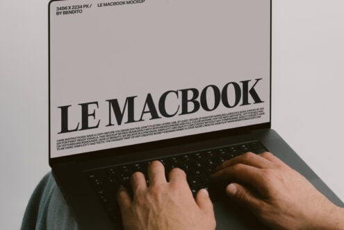 MacBook open showing white screen with black text layout mockup on green background
