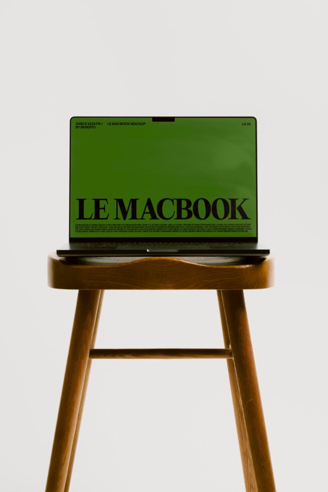 MacBook mockup on wood stool showing green screen with black text layout