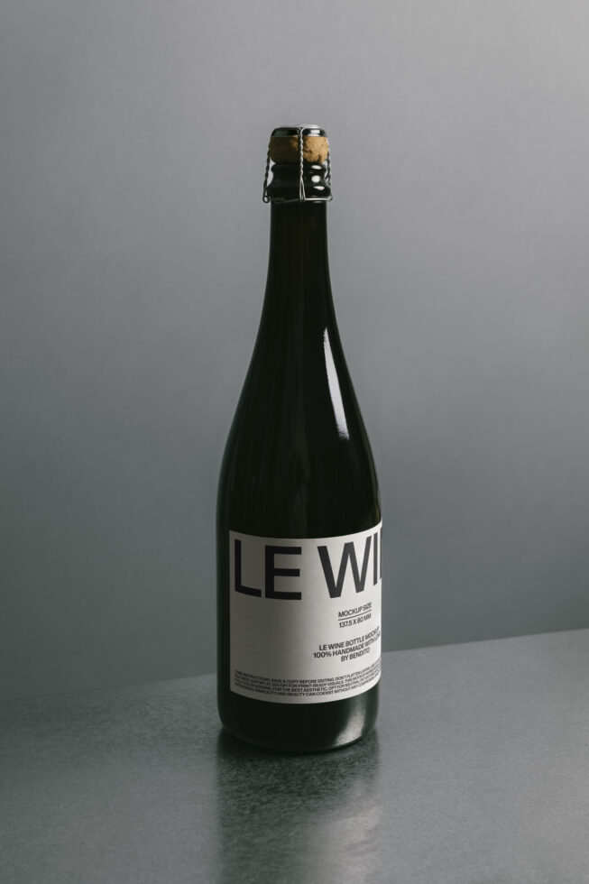 Dark glass bottle with white label mockup on gray surface