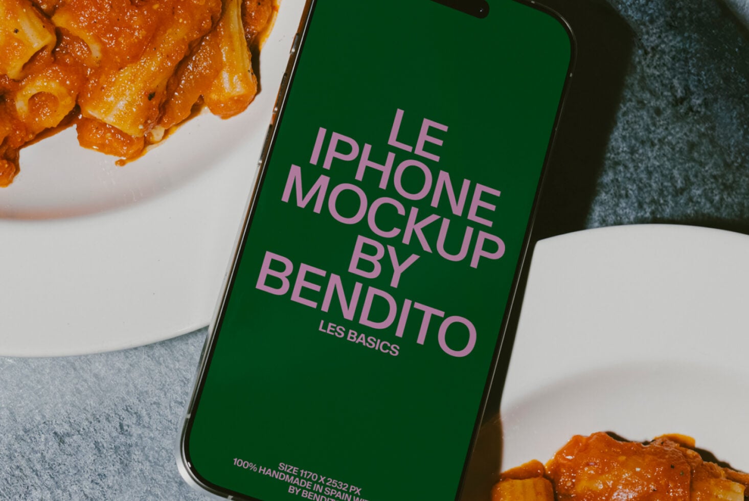 Close up iPhone with green screen mockup next to spicy pasta in white bowl