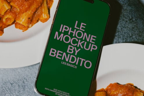 Close up iPhone with green screen mockup next to spicy pasta in white bowl